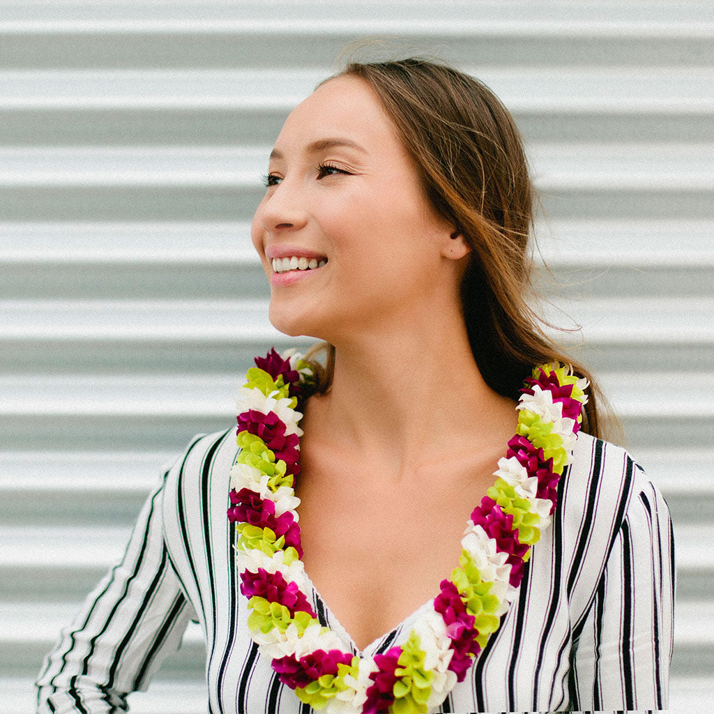Spiral orchid lei using white, green, and purple flowers